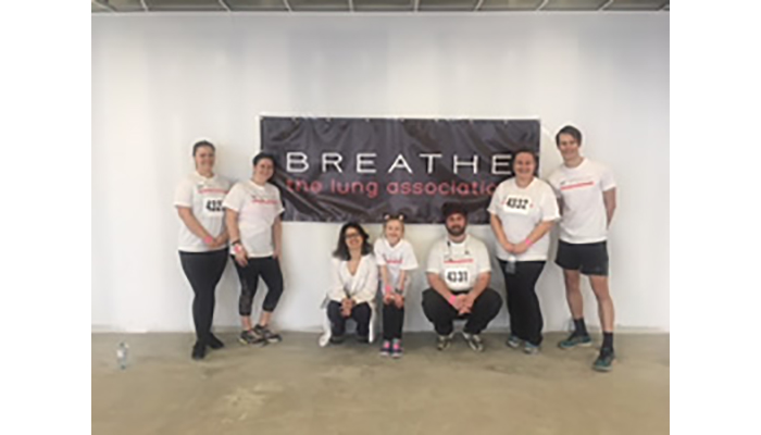 FIRH team in front of a poster at the 2018 stair-climb